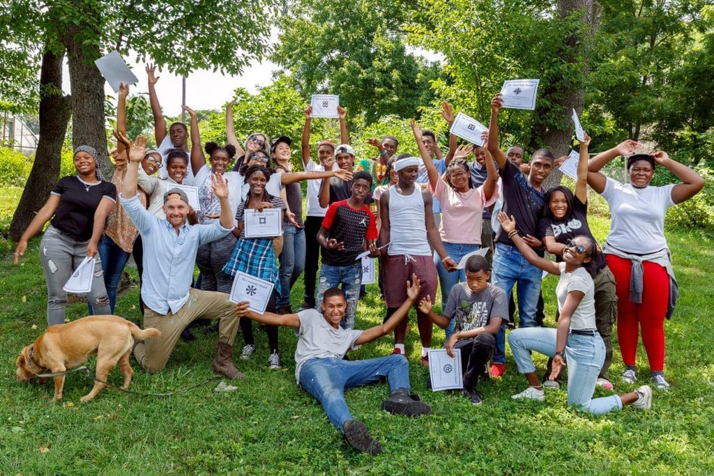 Group of young people smiling and holding certificates