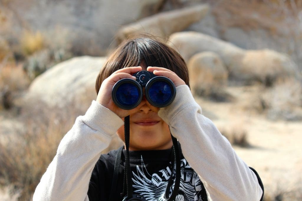 child holding binoculars