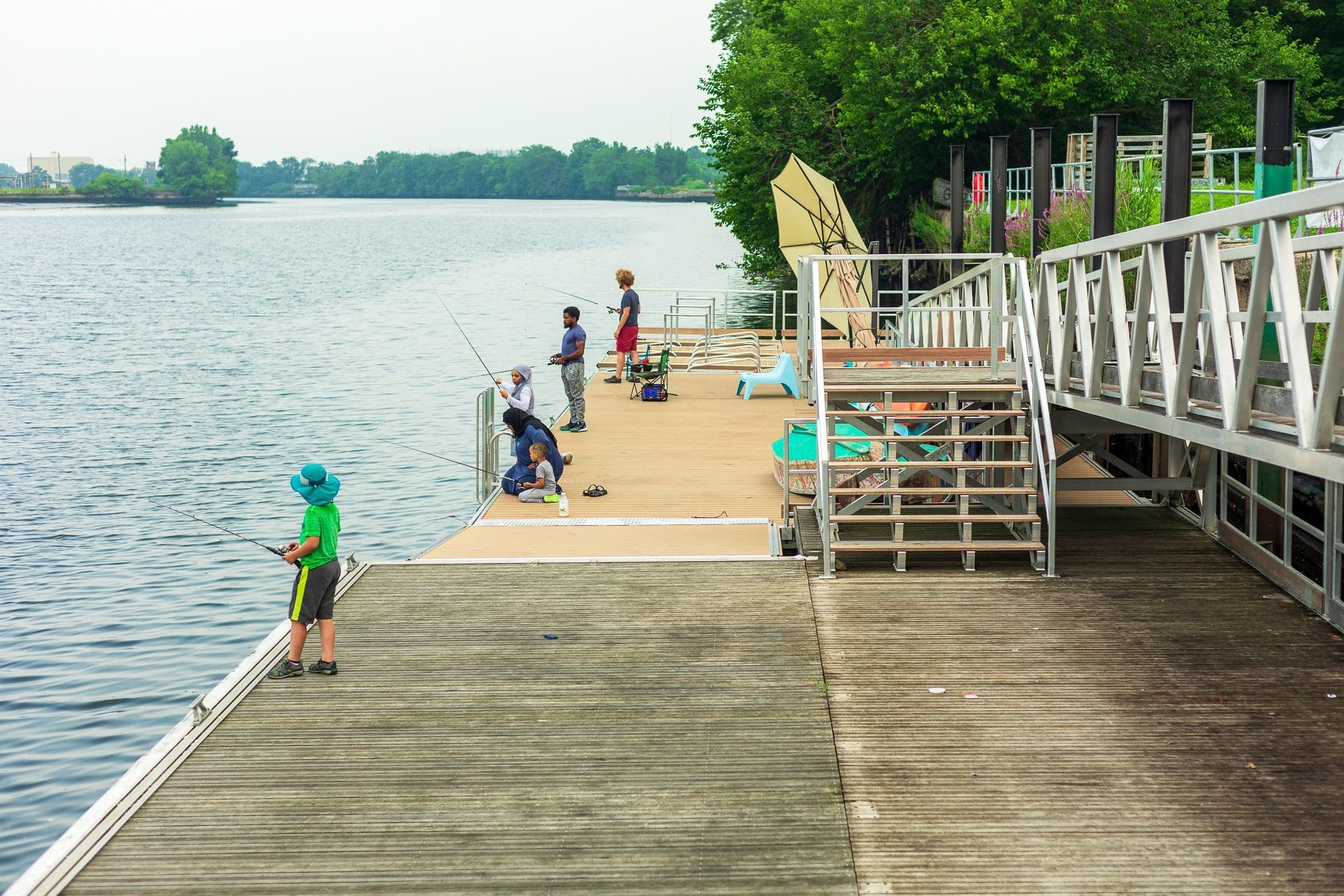 People of all ages fishing on the dock.