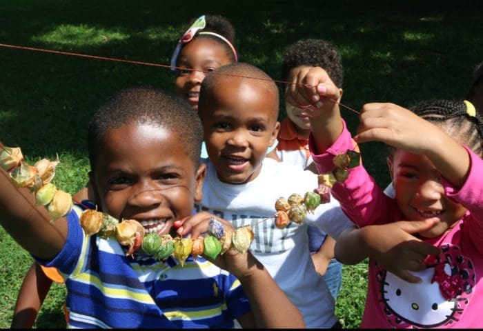 Small children smiling & holding up their crafts