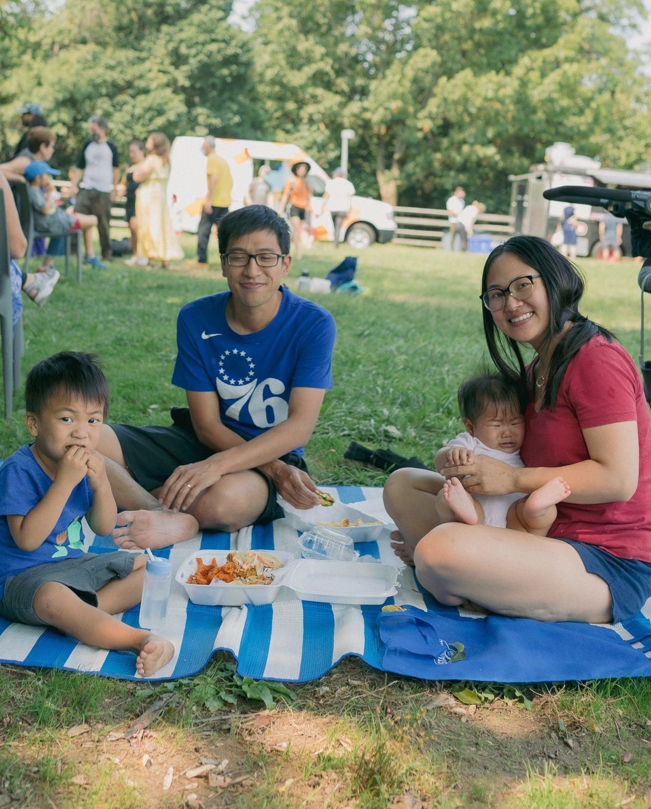 A family picnicking on grass.