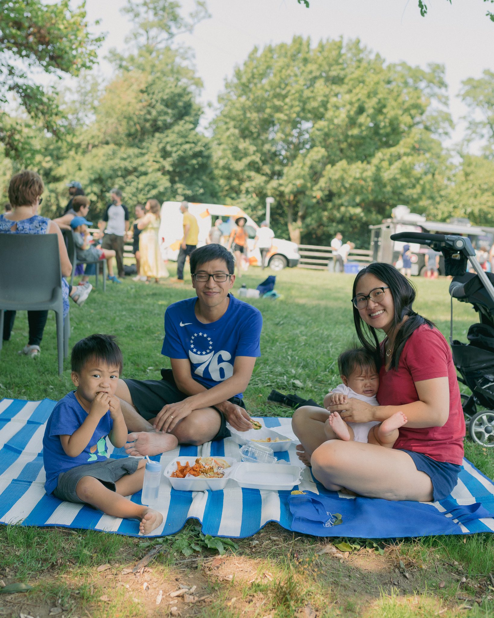 A family picnicking on grass.