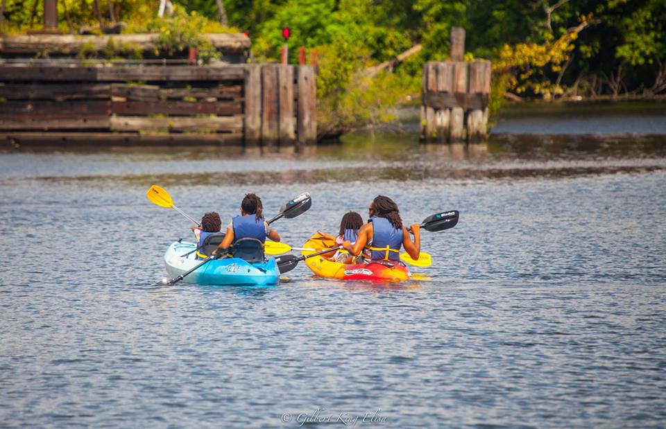 Adults and kids kayaking on the river.