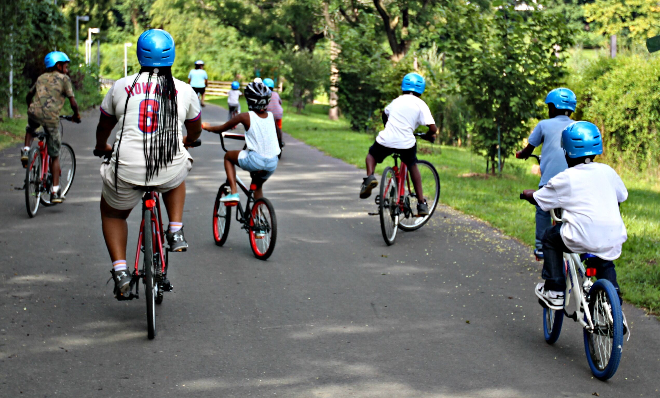 children riding bikes on a trail surrounded by trees