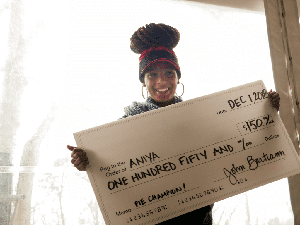 Aniya holds a giant check for her winnings