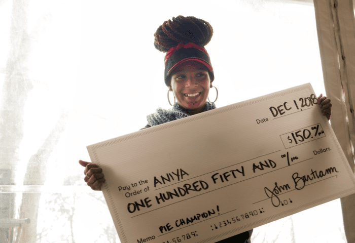 Aniya holds a giant check for her winnings